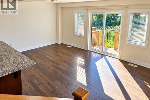 Living area with dark wood floors and a sliding glass door to a deck. - 28 Nieson Street, Cambridge