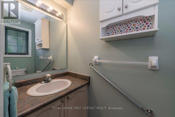 Powder room with a vanity, sink, mirror, and grab bars. - 28 Pass Court, Barrie
