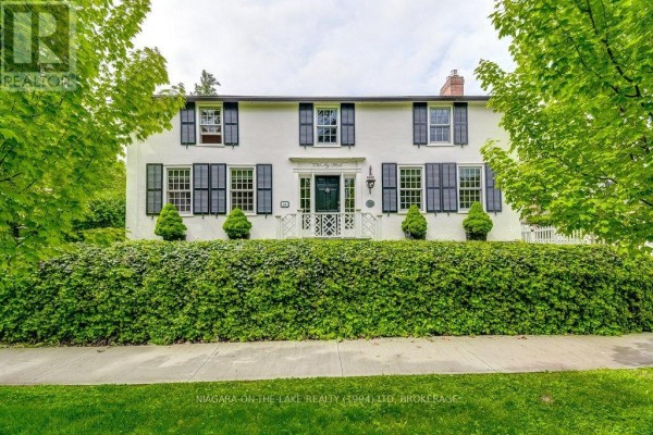 Facade of a white two-story house with black shutters, symmetrical windows, and a central entrance. - 28 Prideaux Street, Niagara On The Lake