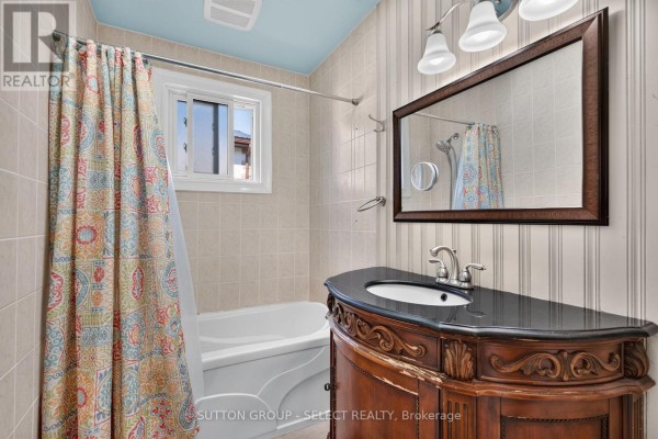 Bathroom with a bathtub, vanity, sink, mirror, and a colorful shower curtain. - 280 Charlotte Street, Central Elgin