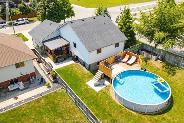 Rear exterior of home with covered porch, wooden deck, and above-ground swimming pool. - 280 Mclellan, Amherstburg
