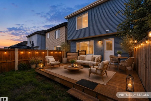 Side view of the front of a blue two-story home with lush green trees. - 2801 Coughlan Green Gr Sw, Edmonton