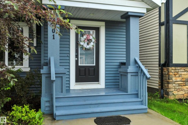 Close-up of the blue front porch and entry door of the home. - 2801 Coughlan Green Gr Sw, Edmonton