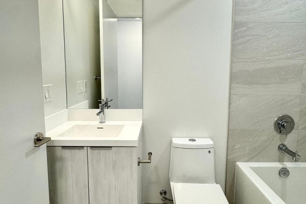 Bathroom with modern vanity, toilet, and bathtub with tiled walls. - 2802 - 400 King Street W, Toronto