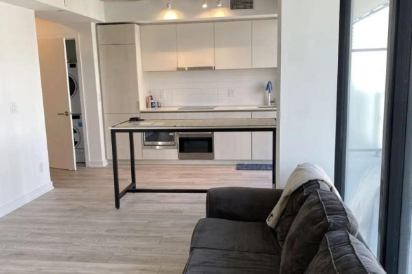 Open-concept living space showing a modern kitchen with white cabinets and a stainless steel island. - 2805 - 47 Mutual Street, Toronto