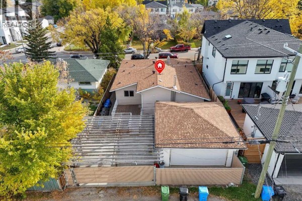 Rear aerial view of the house, backyard, garage, and surrounding fences. - 2807 32 Street Sw, Calgary