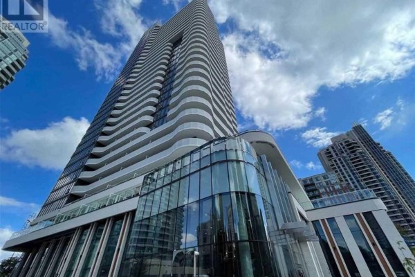 Close-up view of a modern high-rise apartment building's glass entrance and curved balconies. - 2809 - 15 Holmes Avenue, Toronto