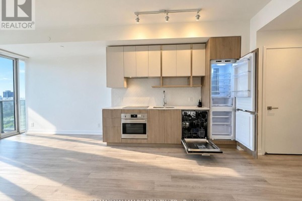 Open-concept kitchen with light wood cabinets, white countertops, and stainless steel appliances. - 2809 - 15 Holmes Avenue, Toronto