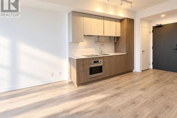 Modern kitchen with light wood cabinets, stainless steel oven, and white countertops in an apartment. - 2809 - 15 Holmes Avenue, Toronto