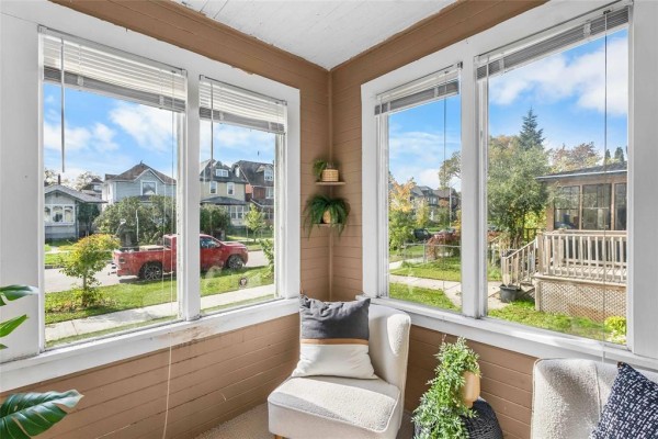 Sunroom with white framed windows and beige painted walls overlooking a street and trees. - 281 Lansdowne Avenue, Winnipeg