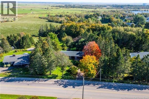 Aerial view of the property and surrounding rural landscape, showing houses, trees, and fields under a clear sky. - 281 Main Street, Sackville