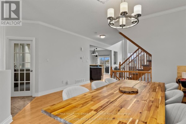Dining room with a wooden table, view of stairs, and hallway. - 281 Topaze Crescent, Clarence Rockland
