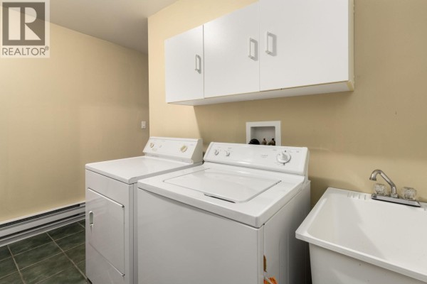 Laundry room with white washer and dryer, and wall-mounted storage - 2813 Clifftop Lane, Whistler