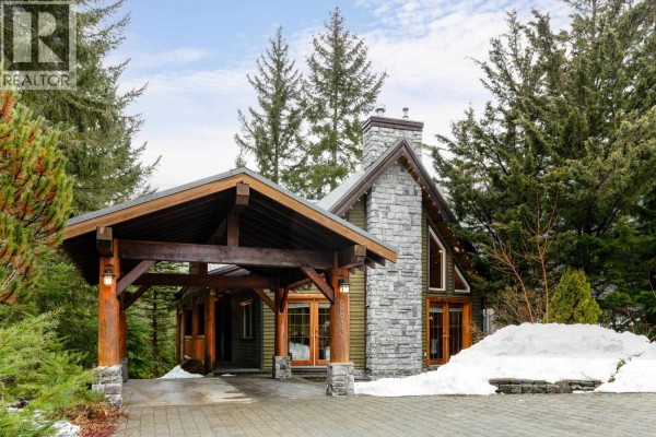 Living room with vaulted ceiling, stone fireplace, and large windows - 2813 Clifftop Lane, Whistler