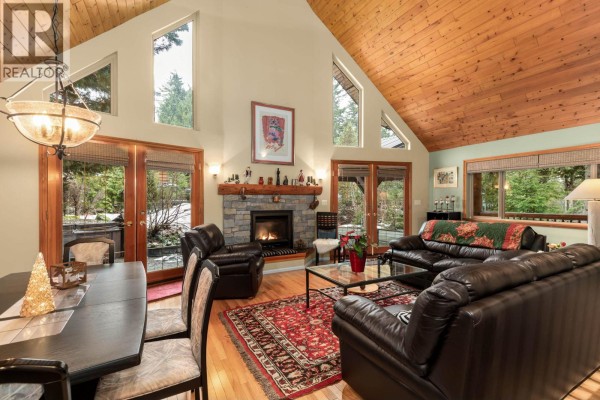 Dining area with wooden table, six chairs, and red accent wall - 2813 Clifftop Lane, Whistler
