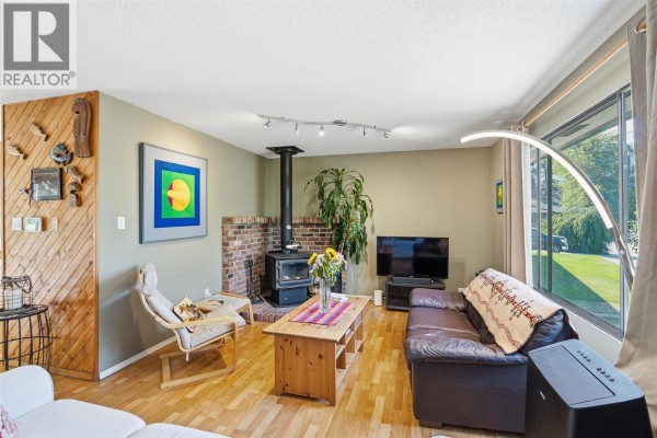 Lawn and garden beds with a wooden deck and steps accessible from the backyard. - 2813 Cranna Crescent, Merritt