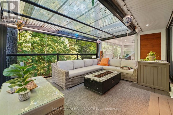 Covered patio with wicker furniture, fire pit, and outdoor seating. - 2814 Forks Of The Credit Road, Caledon