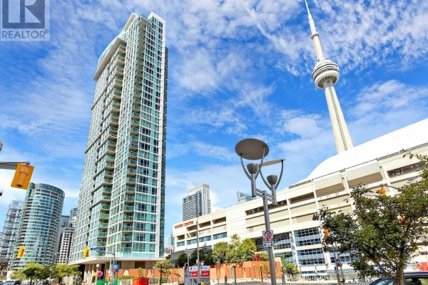 Exterior view of a tall, modern apartment building with balconies and the CN Tower in the background. - 2815 - 81 Navy Wharf Court, Toronto