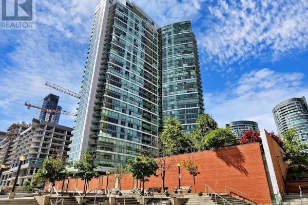 Modern apartment building exterior with balconies, green trees, and a brick podium. - 2815 - 81 Navy Wharf Court, Toronto