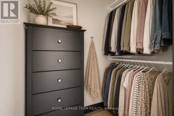 Dark dresser, artwork, and organized closet with hanging clothes - 2815 Golf Course Lane North Grenville