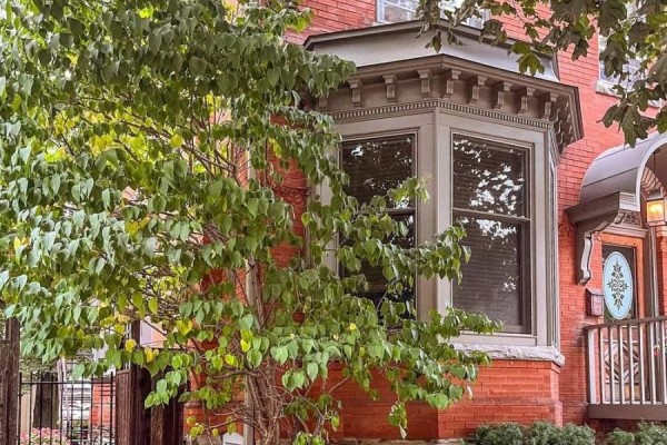 Bay window on the side of the brick house with a tree in front. - 282 Hess Street S, Hamilton
