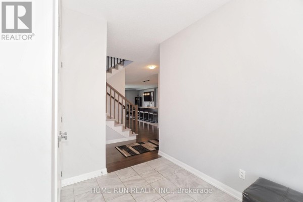 Interior entryway with light grey walls, tiled floor, and dark hardwood stairs. - 282 Nelson Street E, Carleton Place