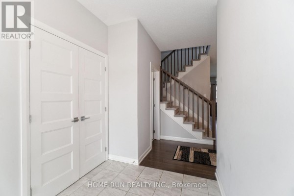 Interior entryway with white double doors, tiled floor, and dark hardwood stairs. - 282 Nelson Street E, Carleton Place