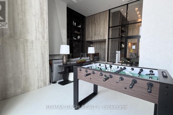 Foosball table in foreground, with seating area and glass-partitioned dining room. - 2820 - 6 Flavelle Trail, Vaughan