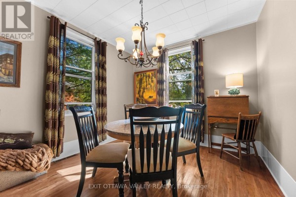 Dining area with round table, chairs, and wooden secretary desk. - 283 & 285 William Street, Pembroke