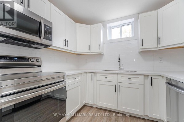 Close-up of white kitchen cabinets, quartz countertop, and stainless steel appliances. - 283 Porter - Lower Level Street, Oshawa