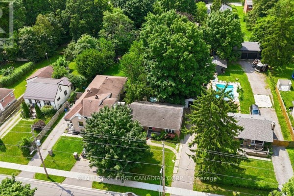 Aerial view of a suburban street with multiple houses, mature trees, and a swimming pool. - 283 Spruce Street, London East