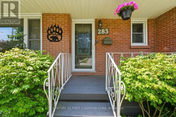 Close-up of the front porch entrance with a glass door, house number 283, and white railings. - 283 Spruce Street, London East