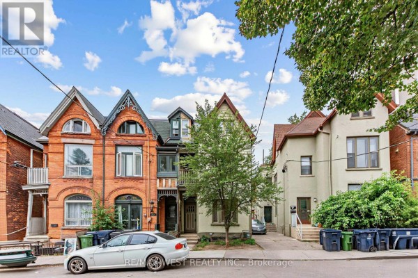 Street view of attached brick houses with a small tree in front of one. - 284 Lisgar Street, Toronto