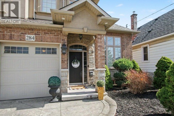 Close-up of the house entrance, featuring a double garage, stone pillars, and a dark front door. - 284 Normanhurst Avenue, Hamilton