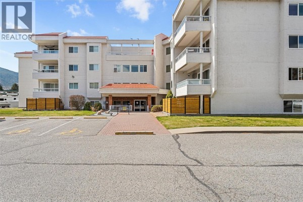 Hallway with numbered wooden storage lockers and a fire door. - 284 Yortkton Avenue Unit# 205, Penticton