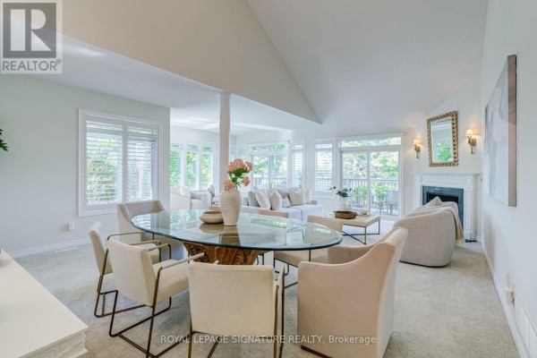 Dining area with a glass-top table, upholstered chairs, and view into a bright living room. - 285 - 8 Lakeside Vista Way, Markham