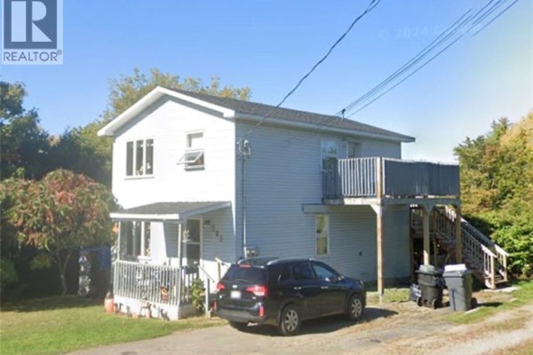Side view of the multifamily home featuring a deck and parking. - 285 Church, Bathurst