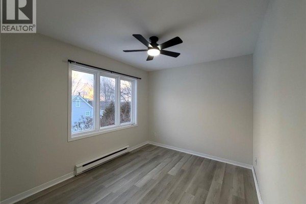 Interior bedroom with a ceiling fan and large window. - 285 Church, Bathurst