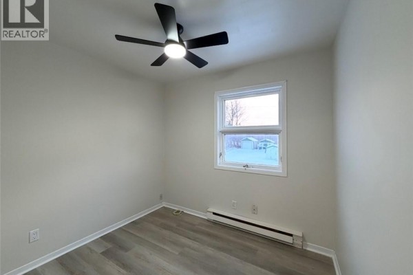 Second interior bedroom with a ceiling fan and window view. - 285 Church, Bathurst