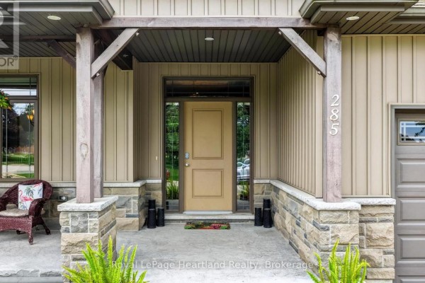 Front entrance with a beige door, sidelights, stone pillars, and house number 285. - 285 Darling Boulevard, South Huron