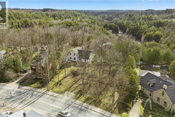 Distant aerial view of houses nestled among trees, with a wide, forested gorge visible in the background. - 285 S Main Street S, Rockwood