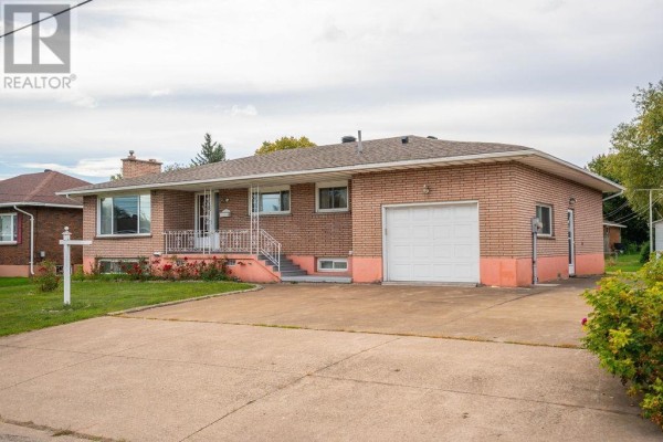 Side view of the house showing the driveway and the attached garage. - 285 Spadina Ave, Sault Ste  Marie