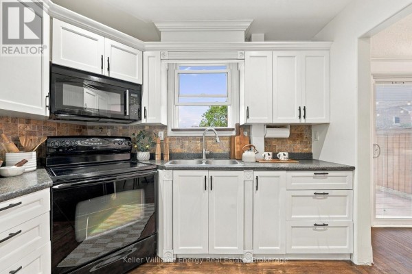Kitchen with white cabinets, black appliances, and granite countertops. - 286 Gliddon Avenue, Oshawa
