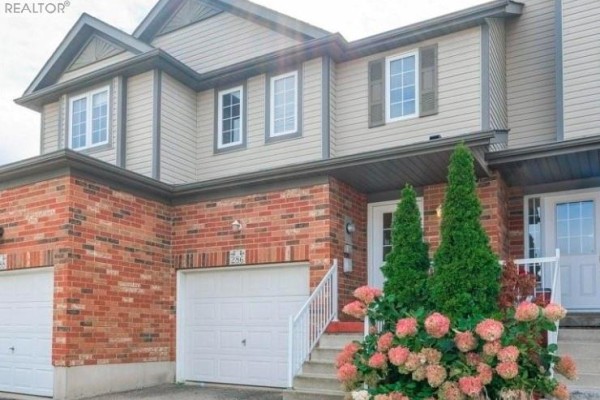 Close-up view of the front door entrance of the townhouse, with a wreath and a doorbell. - 286 Sophia Crescent, Kitchener
