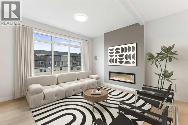 Living room with large window, modern sofa, fireplace, abstract rug, and black chairs. - 286 Waterford Road, Chestermere