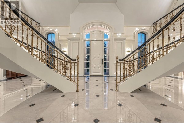 Grand foyer with a sweeping double staircase, marble floors, and a large front door. - 2867 Marine Drive, West Vancouver