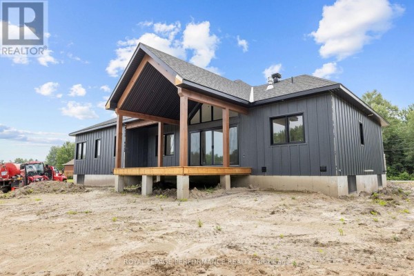 Modern home exterior with dark siding & large covered porch with wood beams - 288 Route 300 East Route The Nation