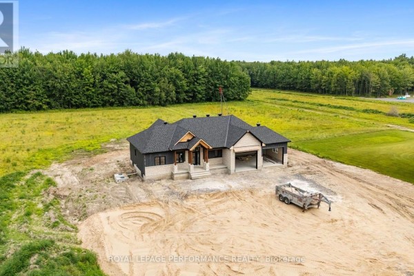 New construction ranch home with dark siding and stone facade, attached garage - Route 300 East Route The Nation