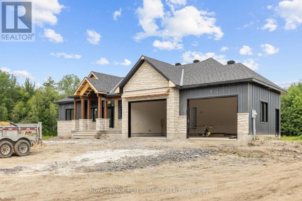 Side view of a house under construction showing the unfinished garage and exterior. - 288 Route 300 East Route, The Nation