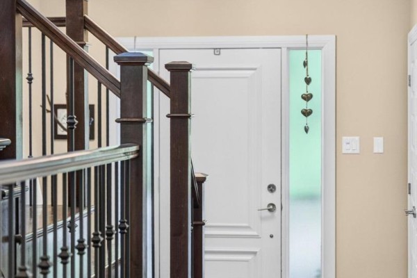 View of a dark wood staircase with metal spindles inside the house. - 288 Selby Avenue, Ottawa